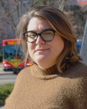 Emily on campus with a KU bus in the background